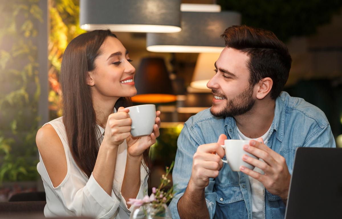 un homme et une femme boivent un café