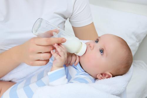 un bébé boit du lait au biberon 